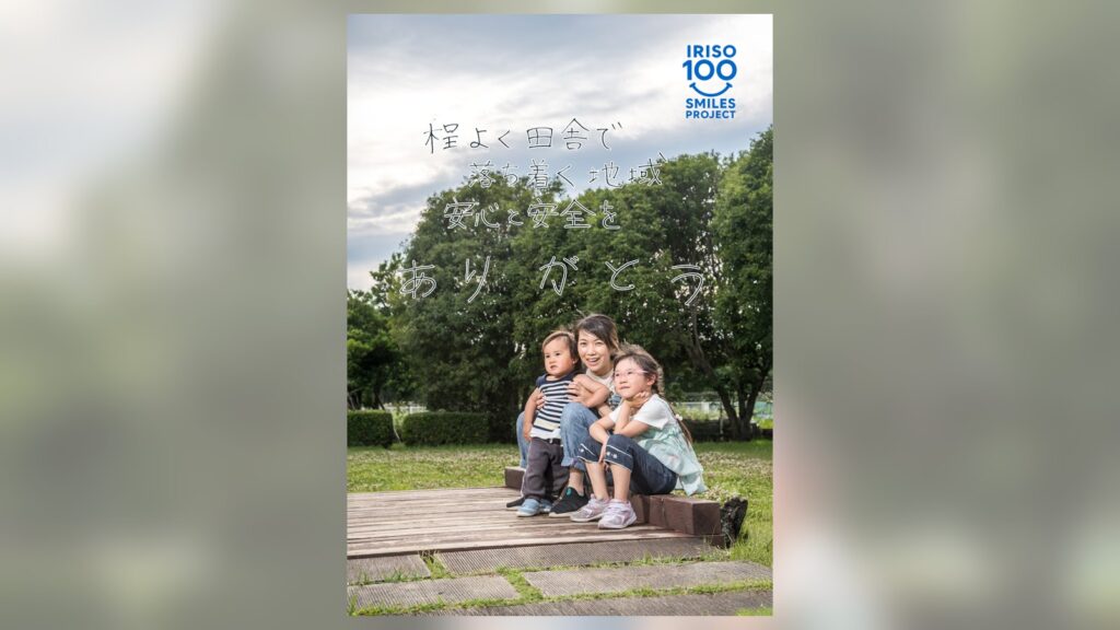 入曽多目的広場のウッドデッキに座るママと2人のお子さん。直筆メッセージ「程よく田舎で落ち着く地域 安心と安全をありがとう」